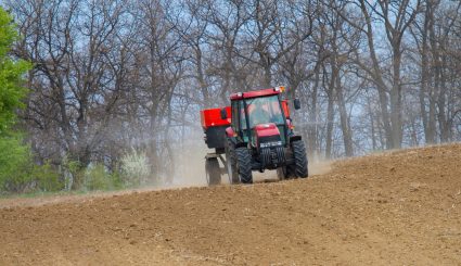An agricultural tractor starts a chemical treatment